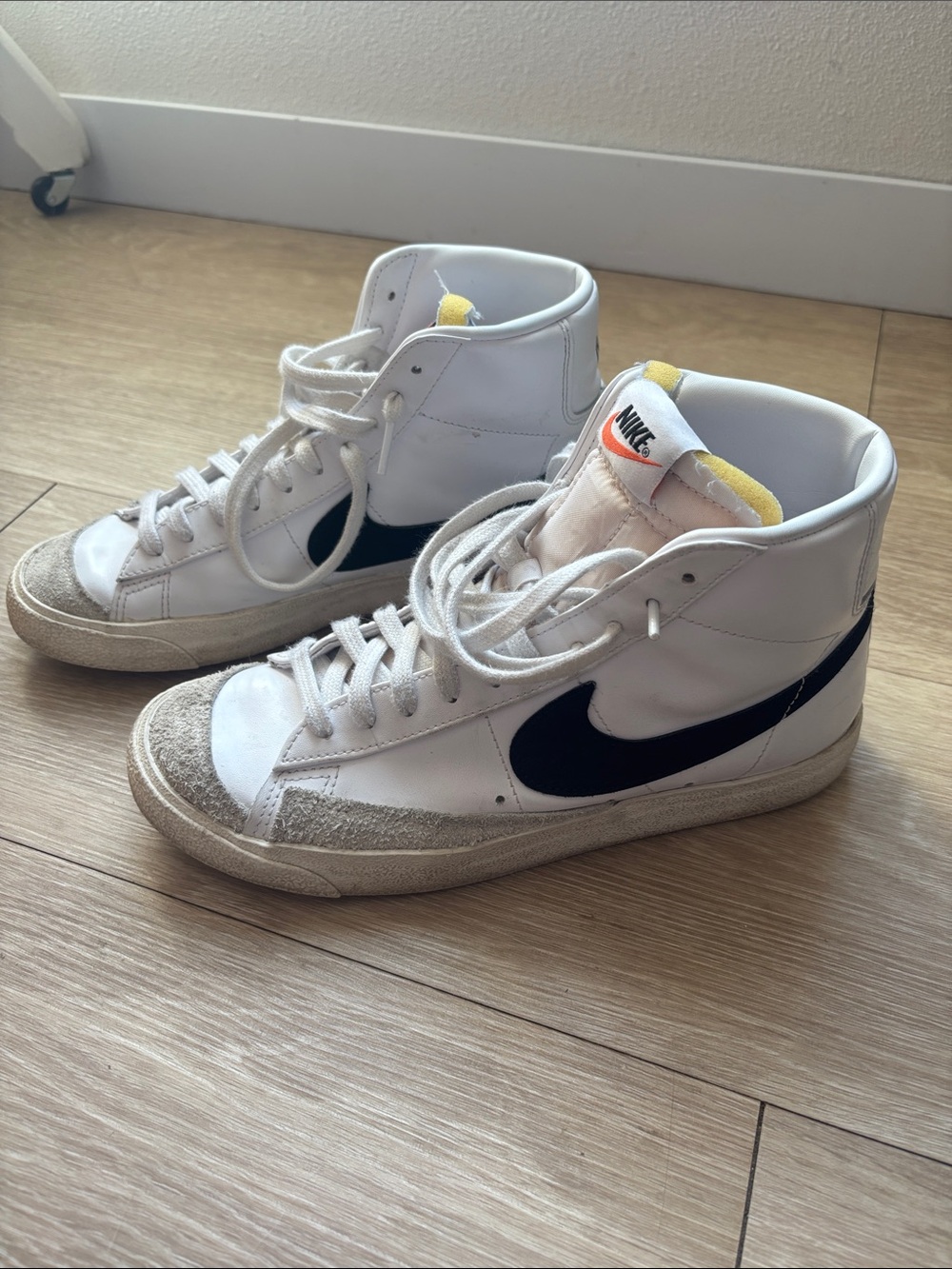 Nike White High-Top Sneakers with Black Swoosh and Yellow Tongue Accents